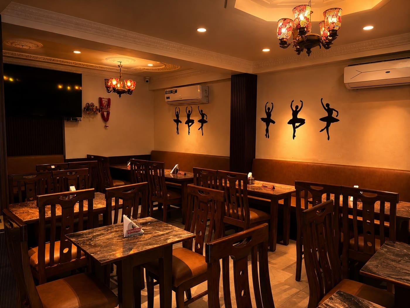 The main dining room with warm lighting and dark wood tables.